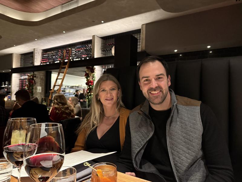 Greg and Natasha at dinner together in a restaurant